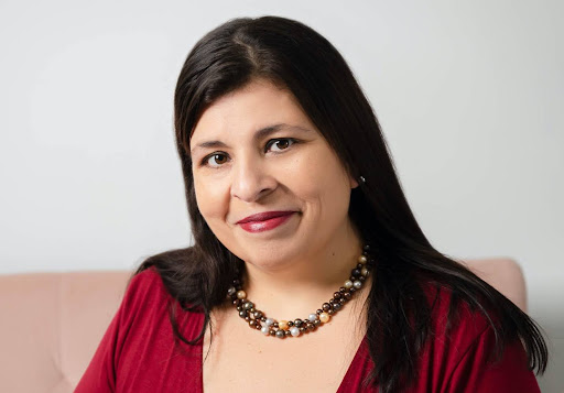 A headshot of Dr. Martinez-Cola in a red top and necklace. 